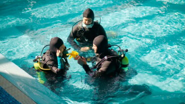 Instructor and divers in aqualungs, dive course