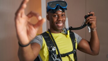 Joyful scuba diver in room showing ok gesture