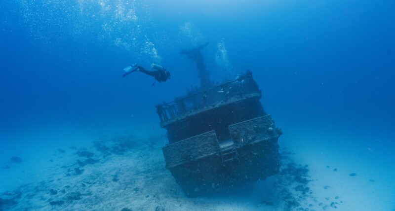scuba diver swimming into a deep wreck