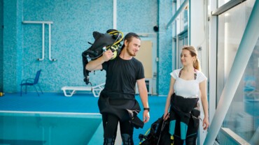 Woman and male instructor in suits, diving school