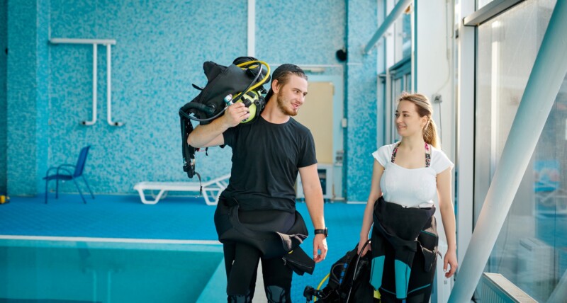 Woman and male instructor in suits, diving school